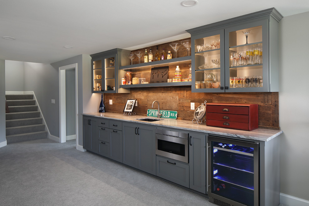 Inspiration for a large transitional single-wall wet bar in Milwaukee with an undermount sink, flat-panel cabinets, grey cabinets, granite benchtops, brown splashback, carpet, grey floor and grey benchtop.