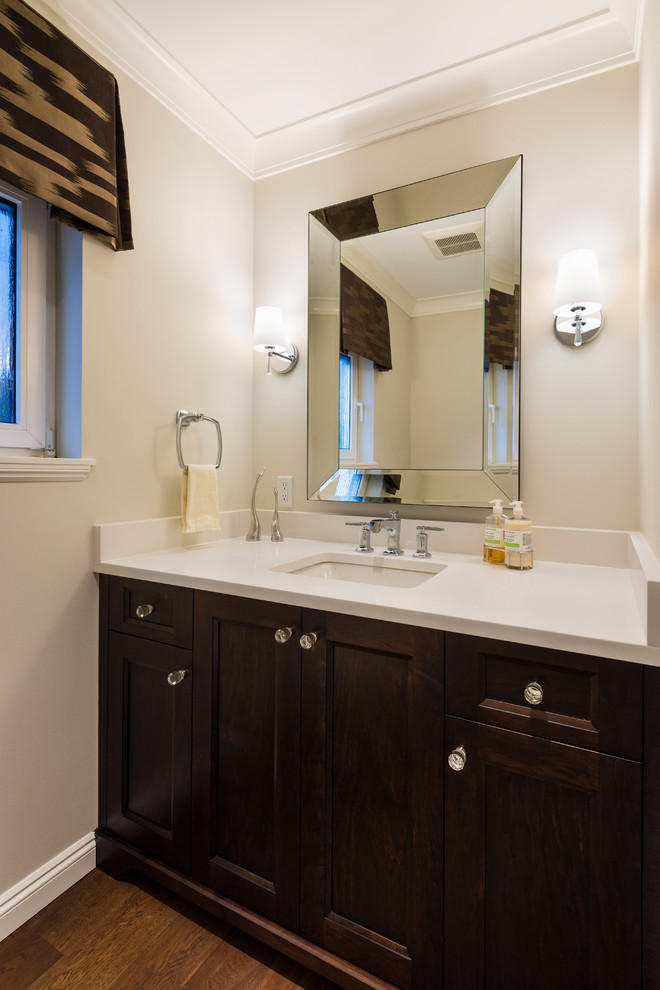 Photo of a small contemporary powder room in Vancouver with shaker cabinets, dark wood cabinets, a one-piece toilet, dark hardwood floors, an undermount sink, quartzite benchtops and white benchtops.