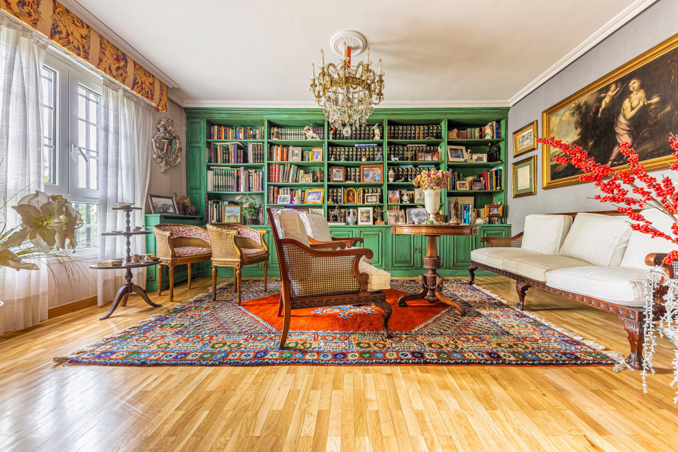 Photo of a large country living room in Madrid with a library, grey walls, light hardwood floors and brown floor.