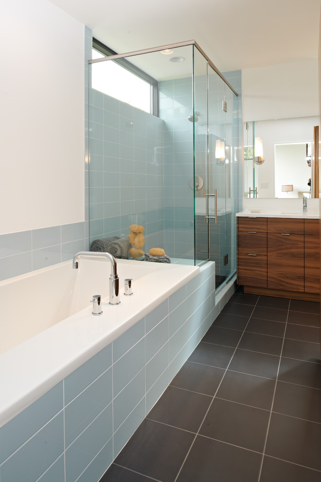 This is an example of a modern bathroom in Minneapolis with flat-panel cabinets, dark wood cabinets, a drop-in tub, a corner shower and blue tile.