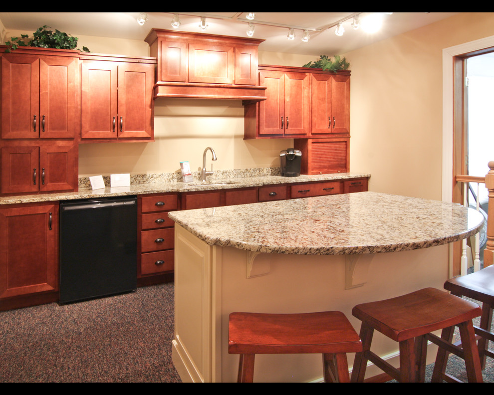 Photo of a mid-sized traditional single-wall eat-in kitchen in Chicago with an undermount sink, shaker cabinets, medium wood cabinets, granite benchtops, black appliances, carpet and with island.