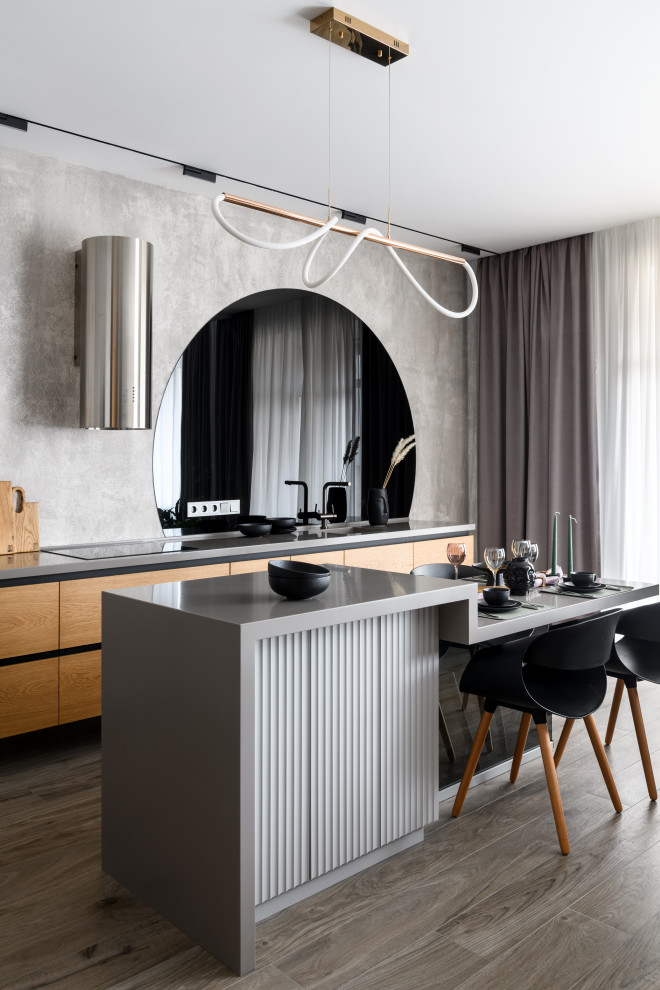 Inspiration for a mid-sized contemporary single-wall eat-in kitchen in Novosibirsk with an integrated sink, flat-panel cabinets, medium wood cabinets, solid surface benchtops, grey splashback, glass sheet splashback, stainless steel appliances, porcelain floors, with island, brown floor and grey benchtop.