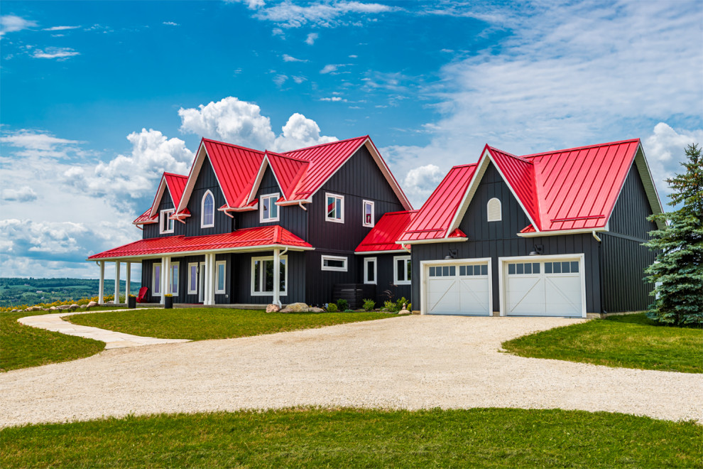 Immagine della villa nera country a due piani con rivestimento in vinile, tetto rosso e pannelli e listelle di legno