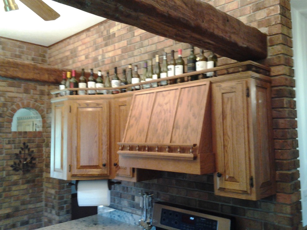 Inspiration for a mid-sized rustic medium tone wood floor enclosed kitchen remodel in Indianapolis with an undermount sink, raised-panel cabinets, medium tone wood cabinets, quartzite countertops, stainless steel appliances and no island