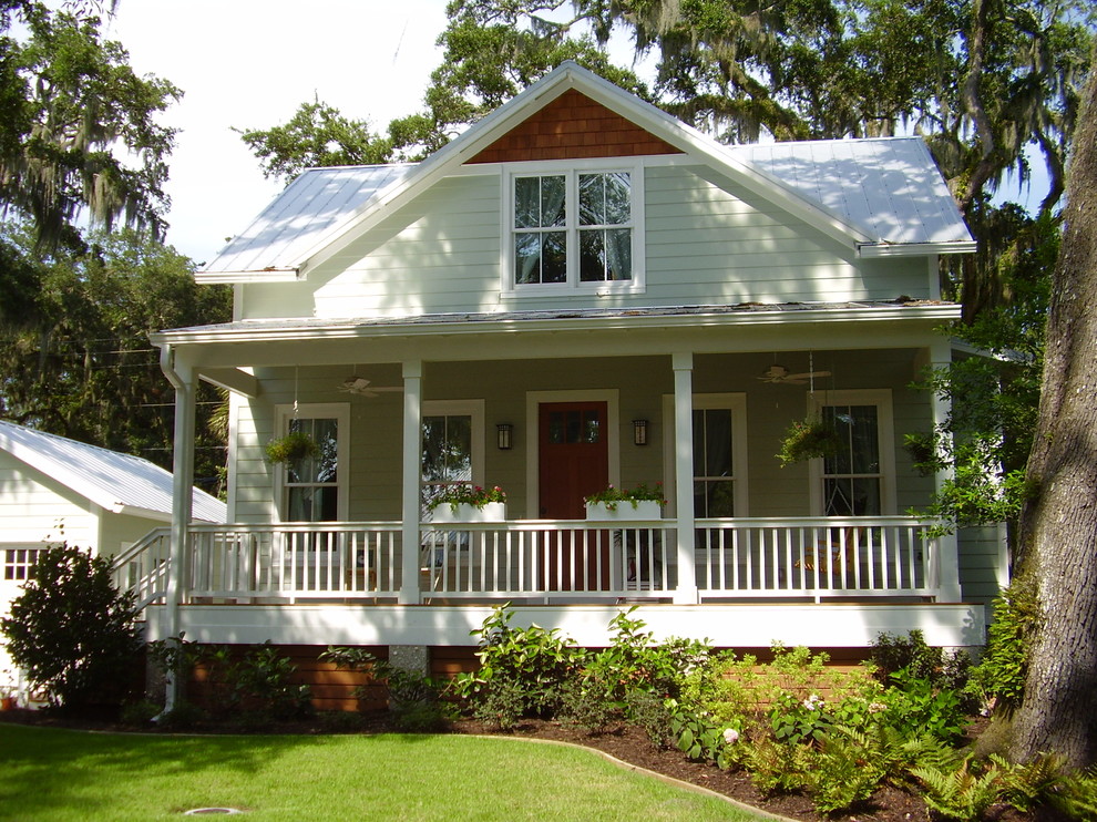 Photo of a mid-sized beach style two-storey house exterior in Jacksonville with vinyl siding, a gable roof and a metal roof.