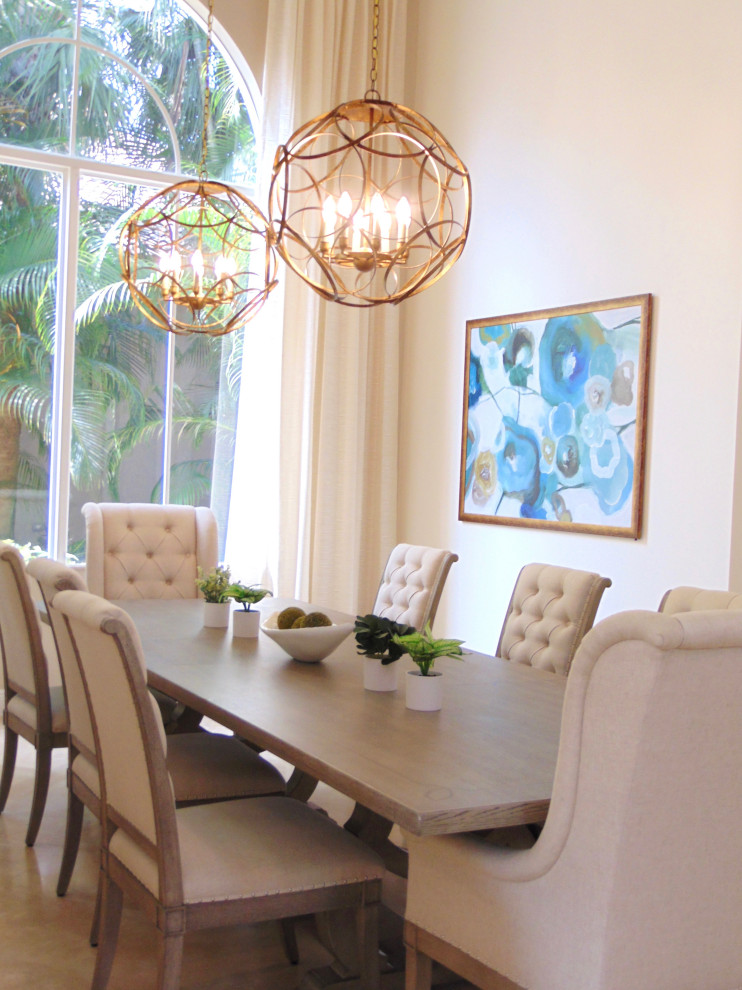 This is an example of a large transitional open plan dining in Miami with white walls, travertine floors and beige floor.