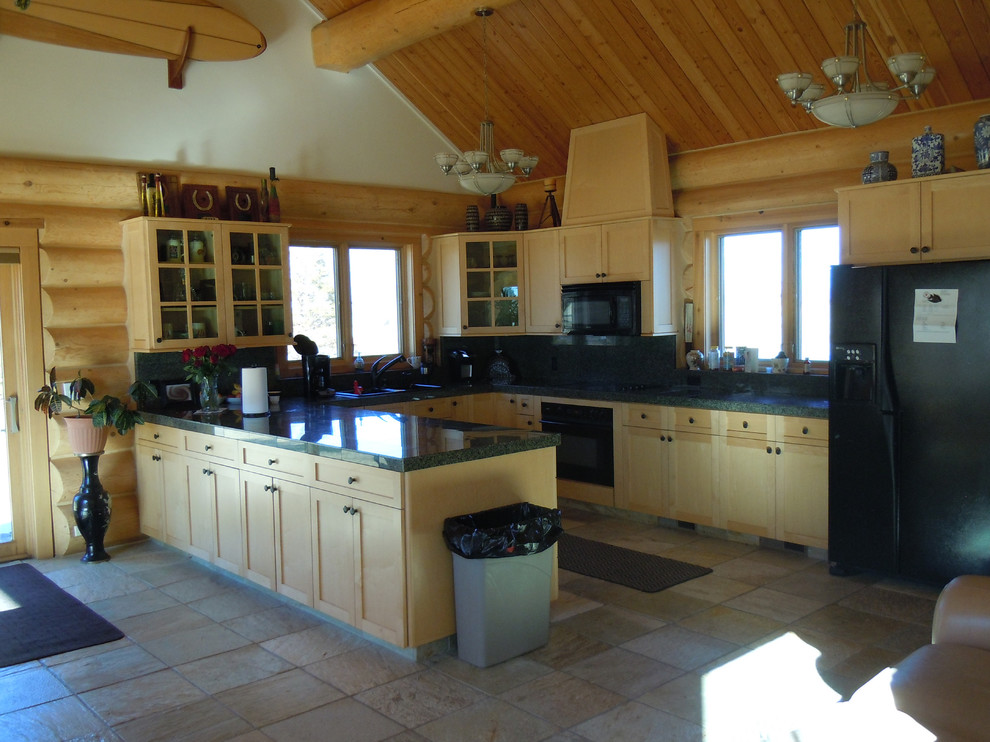 Photo of a mid-sized traditional u-shaped eat-in kitchen in Other with a drop-in sink, recessed-panel cabinets, light wood cabinets, tile benchtops, green splashback, stone tile splashback, black appliances and no island.