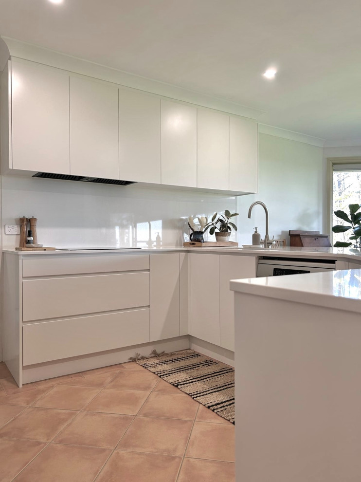 Design ideas for a mid-sized modern u-shaped separate kitchen in Sydney with an undermount sink, flat-panel cabinets, white cabinets, quartz benchtops, white splashback, engineered quartz splashback, stainless steel appliances, ceramic floors and white benchtop.