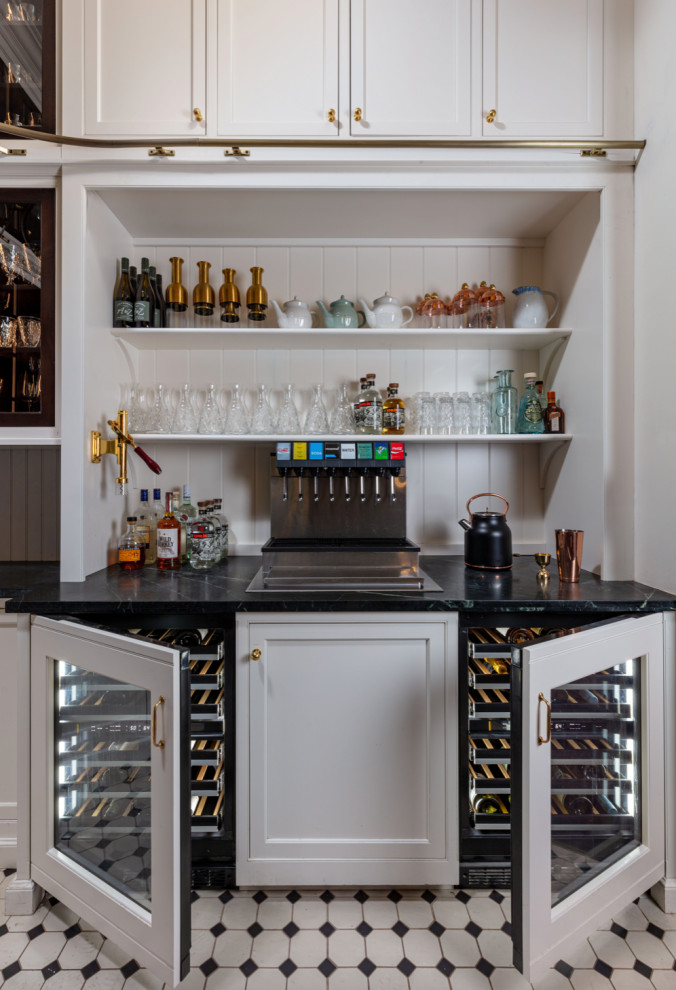 Small traditional single-wall bar cart in New York with an integrated sink, flat-panel cabinets, white cabinets, marble benchtops, white splashback, ceramic splashback, porcelain floors, multi-coloured floor and black benchtop.
