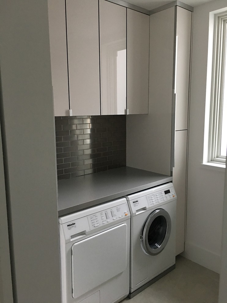Photo of a small contemporary single-wall dedicated laundry room in Miami with flat-panel cabinets, white cabinets, quartz benchtops, white walls and a side-by-side washer and dryer.
