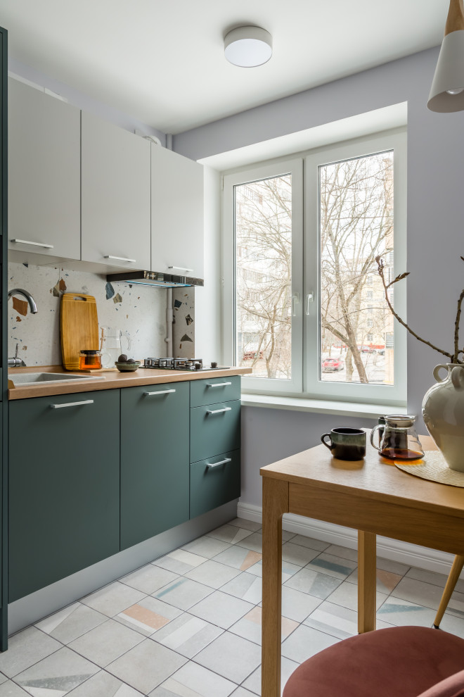 Inspiration for a small scandi single-wall kitchen/diner in Moscow with a built-in sink, flat-panel cabinets, green cabinets, laminate countertops, white splashback, ceramic splashback, black appliances, porcelain flooring, grey floors and beige worktops.