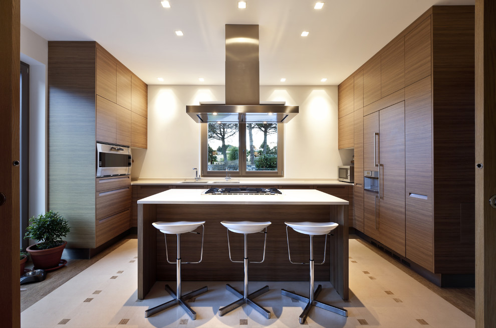 Example of a mid-sized minimalist u-shaped cement tile floor and beige floor eat-in kitchen design with an undermount sink, flat-panel cabinets, dark wood cabinets, quartz countertops, paneled appliances and an island