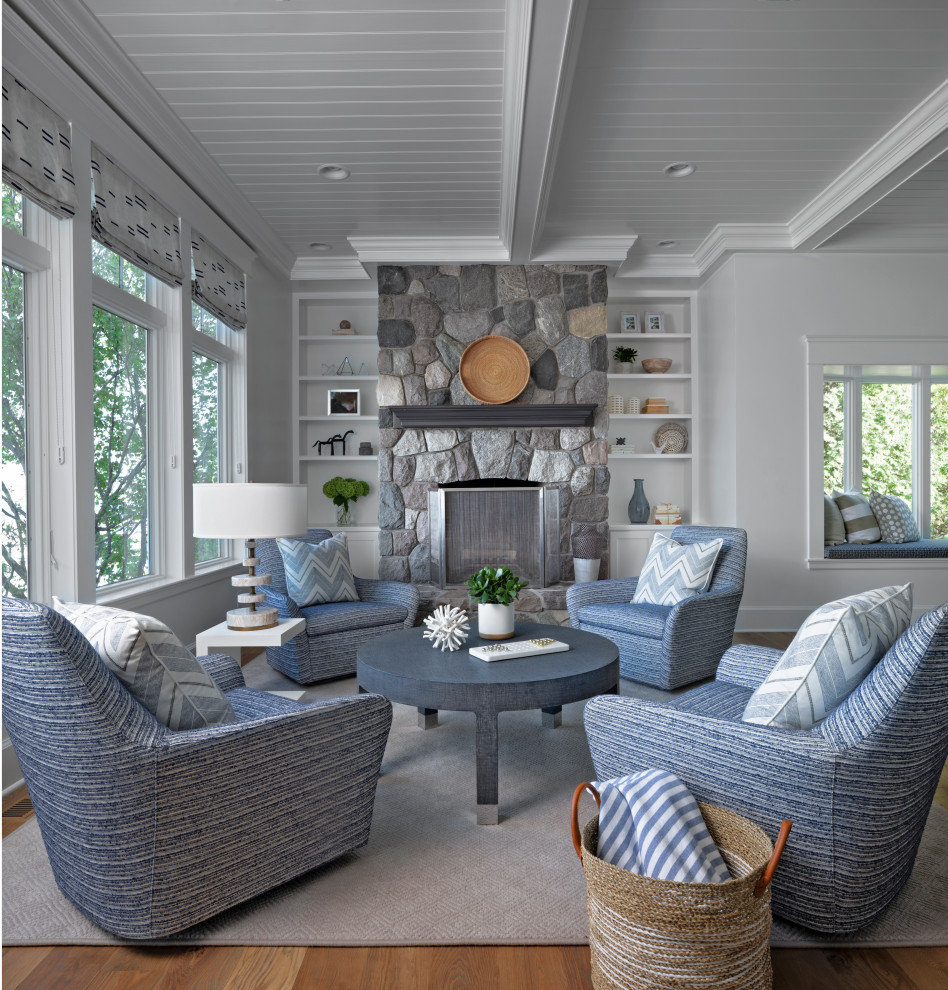 Inspiration for a mid-sized coastal open concept medium tone wood floor family room remodel in Other with white walls, a standard fireplace, a stone fireplace and no tv