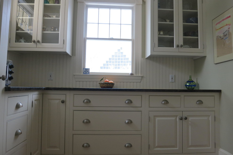 Large transitional l-shaped porcelain tile kitchen pantry photo in Boston with an undermount sink, raised-panel cabinets, white cabinets, granite countertops, white backsplash, stainless steel appliances and an island