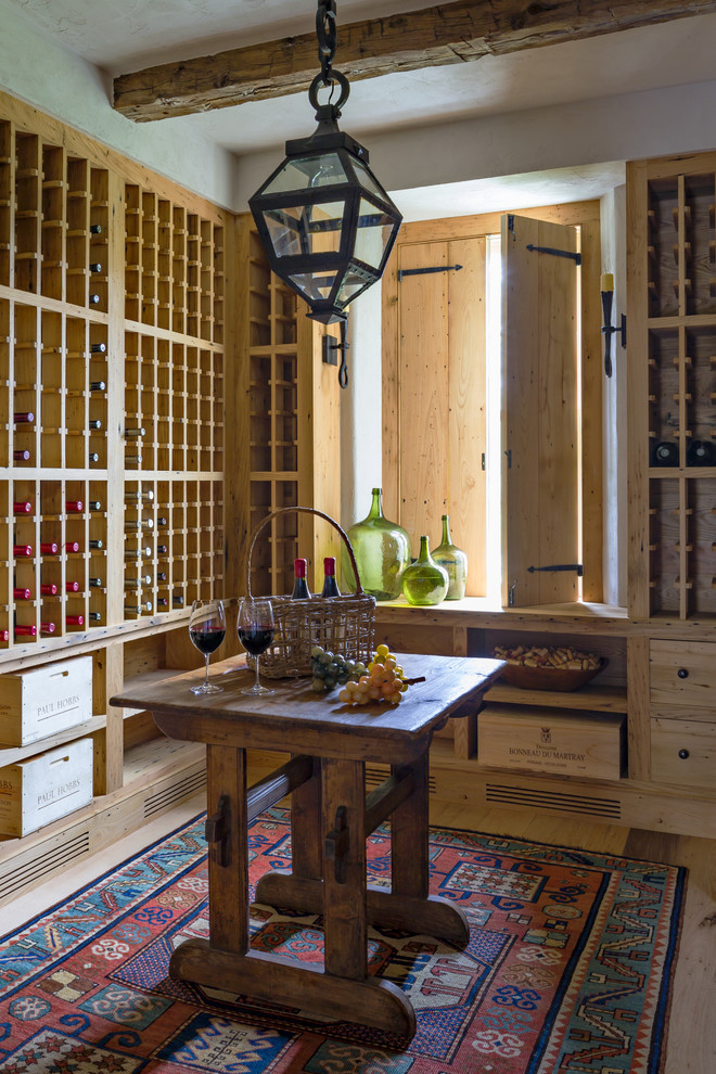 Large country wine cellar in New York with light hardwood floors, storage racks and beige floor.