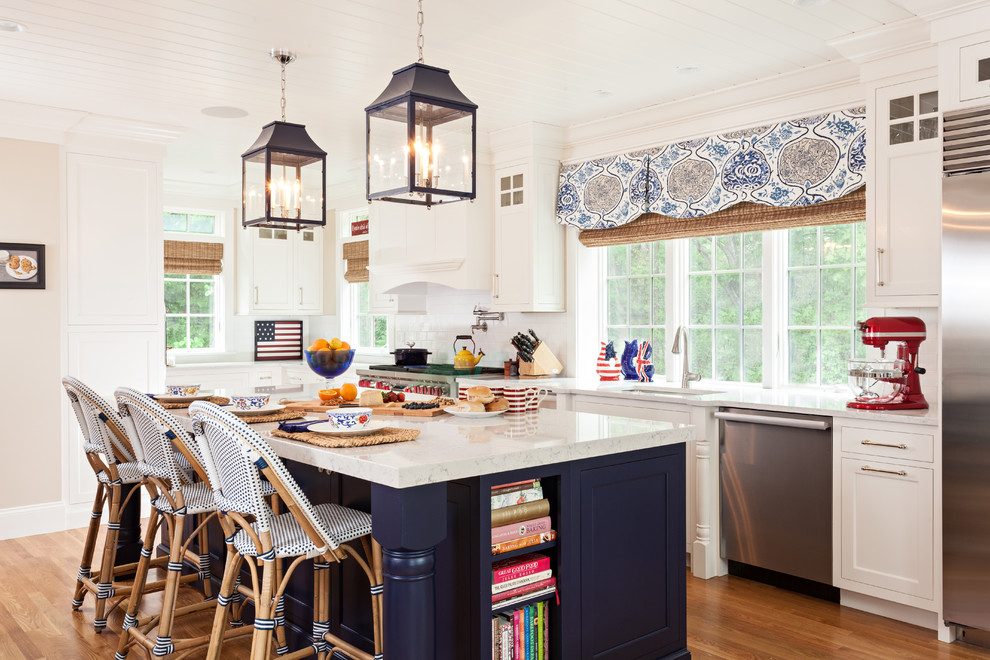 Inspiration for a beach style single-wall kitchen in Boston with white cabinets, white splashback, stainless steel appliances, with island, an undermount sink, shaker cabinets and medium hardwood floors.
