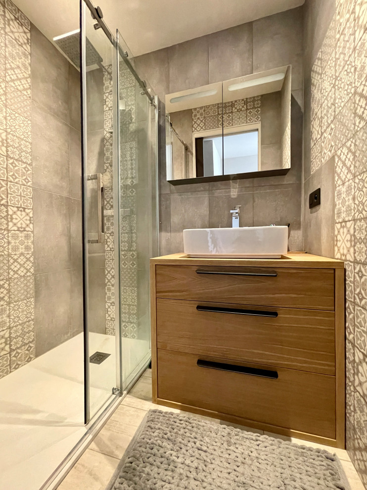 This is an example of a small contemporary shower room bathroom in Lyon with light wood cabinets, a built-in bath, grey tiles, stone tiles, grey walls, ceramic flooring, a console sink, wooden worktops, grey floors, a sliding door and a single sink.
