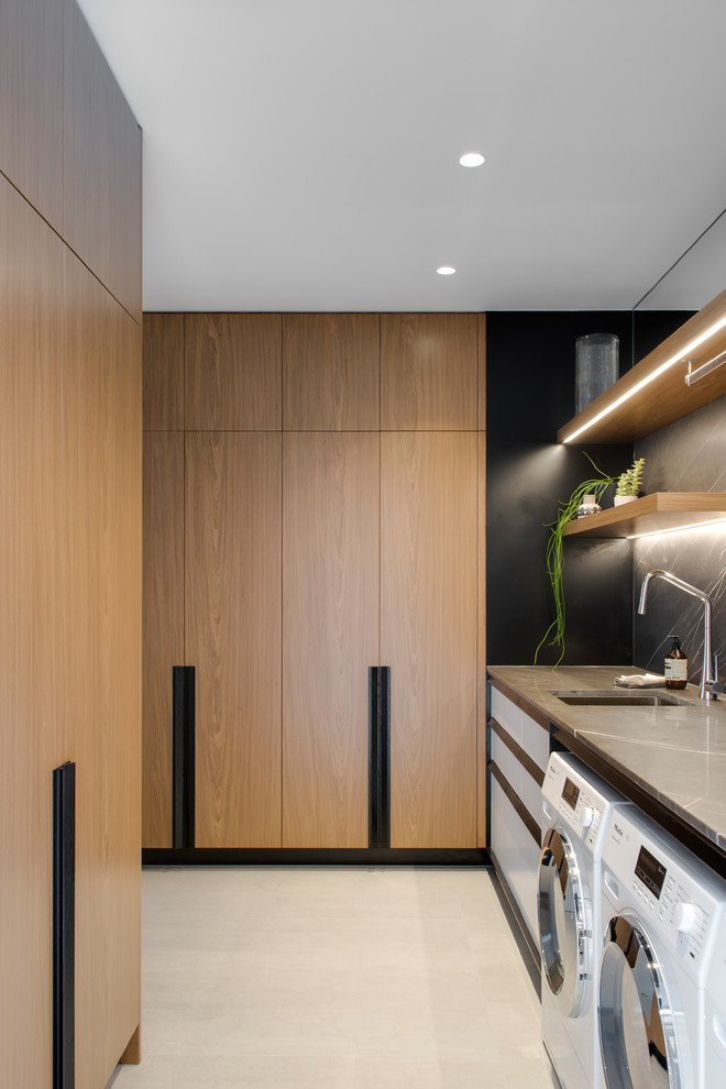 Design ideas for a large contemporary galley kitchen pantry in Sydney with a double-bowl sink, flat-panel cabinets, white cabinets, recycled glass benchtops, grey splashback, marble splashback, black appliances, porcelain floors, with island, grey floor and black benchtop.