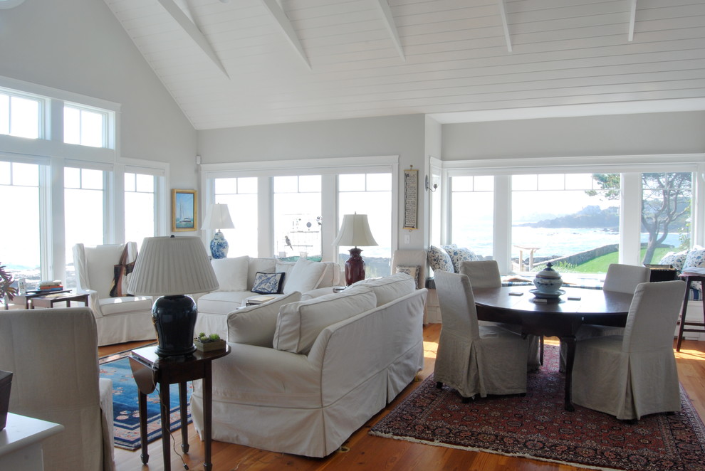 This is an example of a mid-sized beach style formal open concept living room in Portland Maine with grey walls, medium hardwood floors, a standard fireplace, no tv, a wood fireplace surround and brown floor.