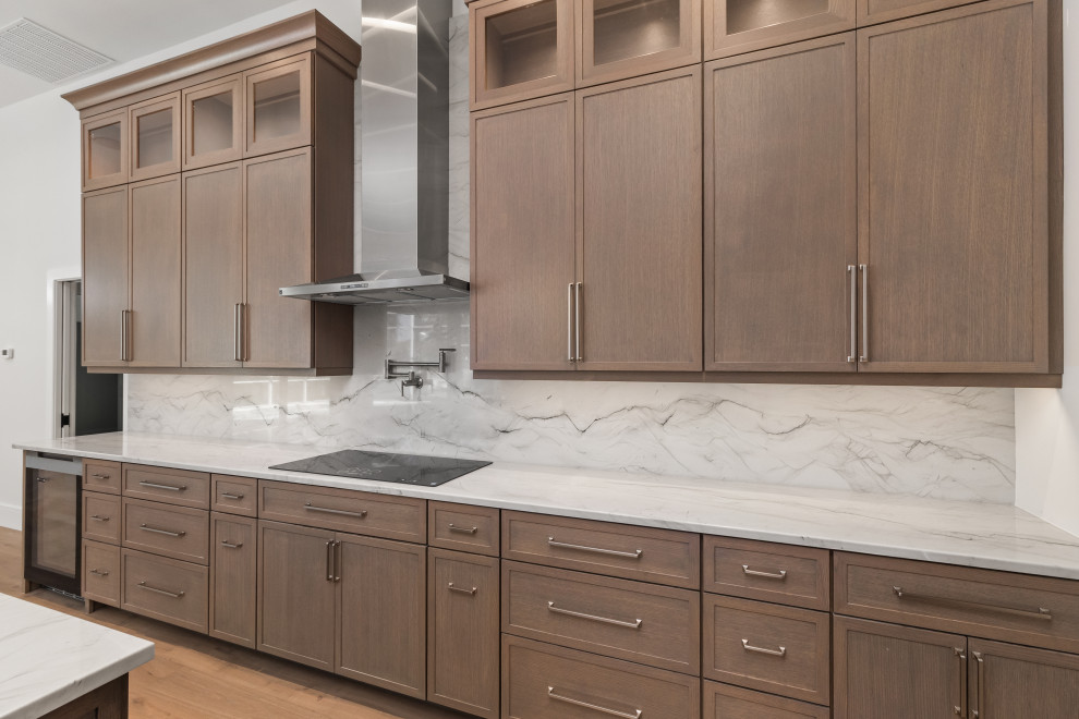 Large transitional galley light wood floor and brown floor eat-in kitchen photo in Tampa with a double-bowl sink, shaker cabinets, dark wood cabinets, quartz countertops, gray backsplash, stone slab backsplash, stainless steel appliances, an island and gray countertops