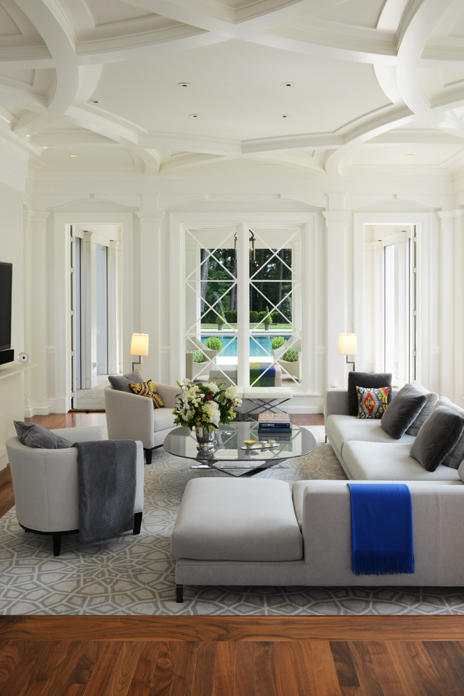 Traditional family room in Boston with white walls and medium hardwood floors.