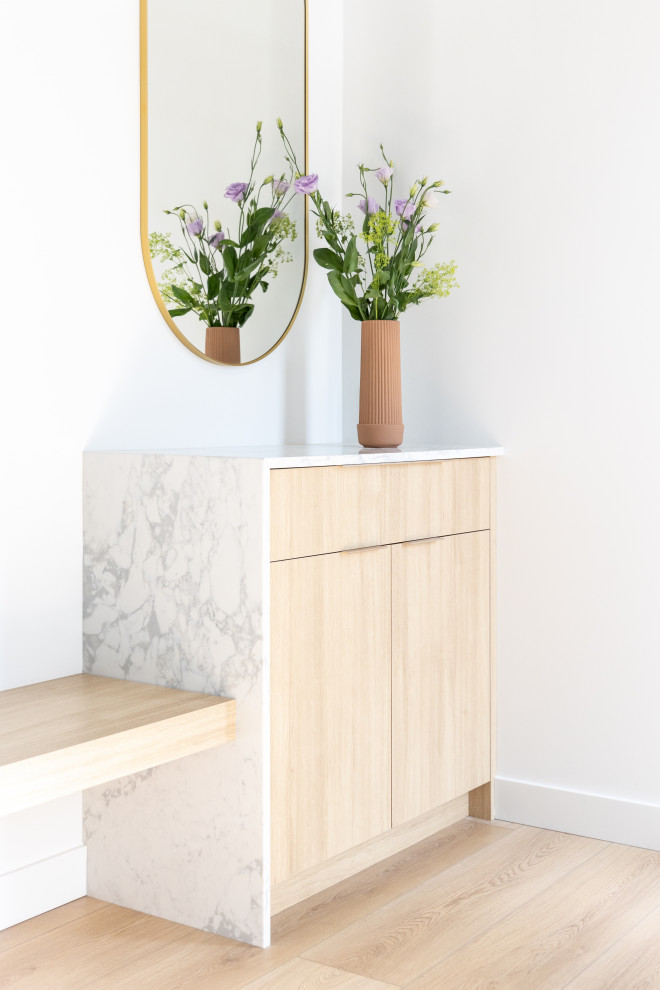Mid-sized trendy light wood floor and beige floor foyer photo in Vancouver with white walls