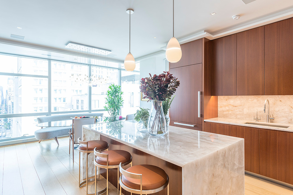 Example of a trendy light wood floor eat-in kitchen design in New York with an undermount sink, flat-panel cabinets, medium tone wood cabinets, beige backsplash, paneled appliances and an island