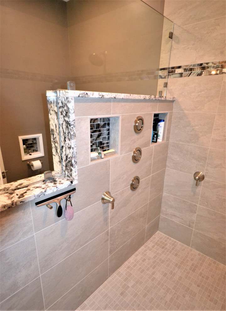 Inspiration for a large traditional ensuite bathroom in Philadelphia with raised-panel cabinets, brown cabinets, a built-in shower, a bidet, beige tiles, ceramic tiles, beige walls, ceramic flooring, a submerged sink, granite worktops, beige floors, an open shower, multi-coloured worktops, an enclosed toilet, a single sink and a built in vanity unit.
