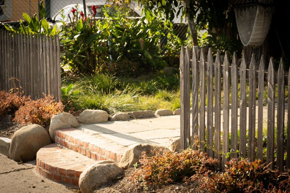 Mittelgroßer Stilmix Garten im Frühling mit direkter Sonneneinstrahlung, Pflastersteinen und Holzzaun in Los Angeles