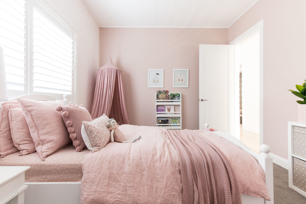 This is an example of a mid-sized traditional kids' bedroom for kids 4-10 years old and girls in Sydney with pink walls, carpet and beige floor.