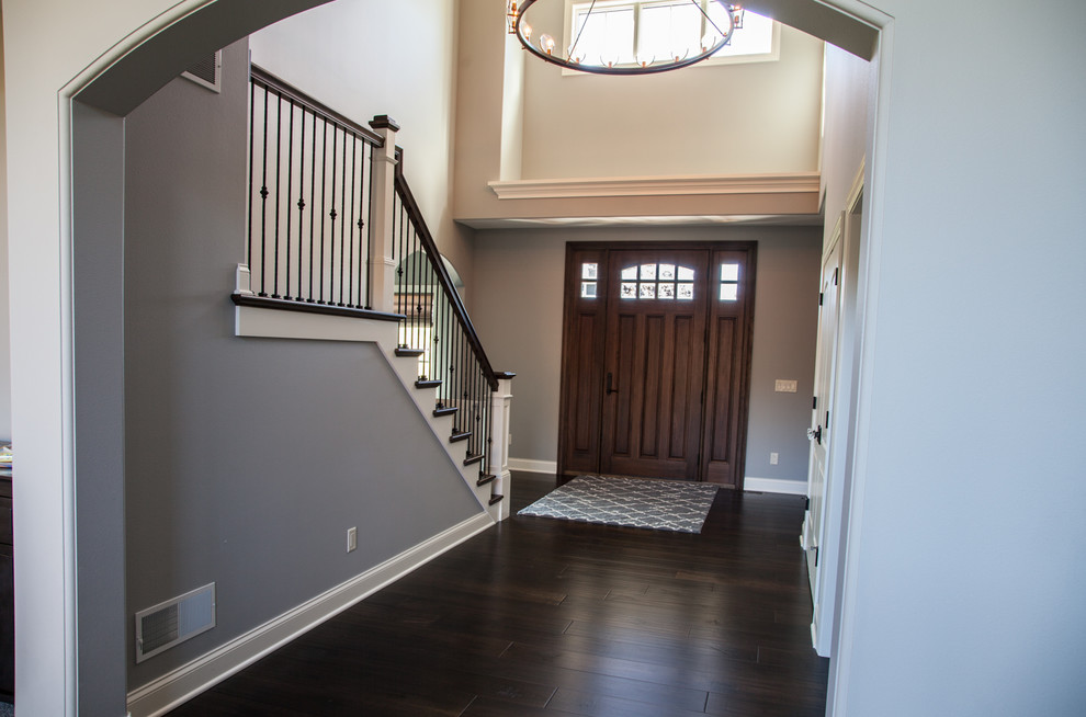 Inspiration for a large transitional dark wood floor and brown floor foyer remodel with gray walls and a dark wood front door