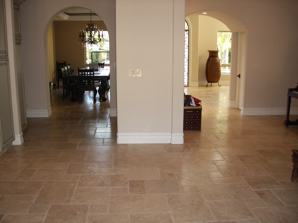 Photo of a small mediterranean hallway in Los Angeles with beige walls, travertine floors and multi-coloured floor.