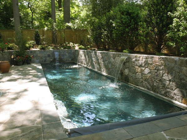 Small contemporary backyard rectangular lap pool in DC Metro with natural stone pavers.