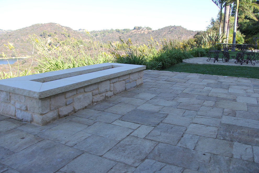 This is an example of a mid-sized traditional backyard patio in Los Angeles with a fire feature and concrete pavers.