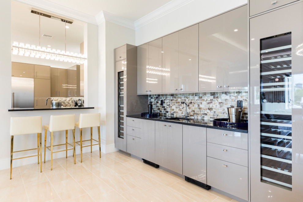 Large contemporary single-wall wet bar in Orlando with an undermount sink, flat-panel cabinets, grey cabinets, solid surface benchtops, multi-coloured splashback, mosaic tile splashback, porcelain floors, beige floor and black benchtop.