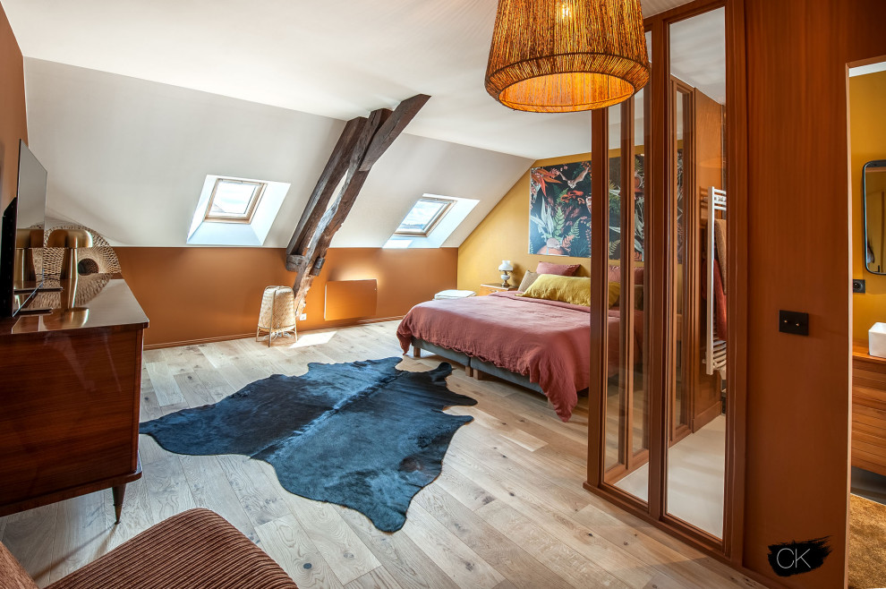 Idéer för att renovera ett mellanstort lantligt sovrum, med gula väggar och ljust trägolv