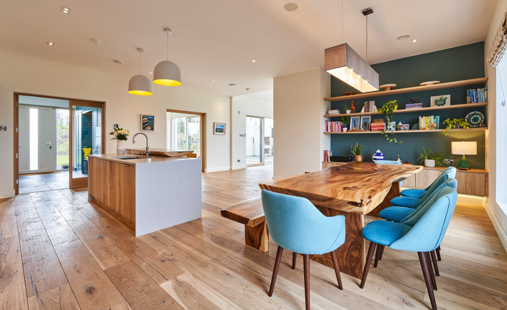 This is an example of a large contemporary single-wall open plan kitchen in Other with a drop-in sink, shaker cabinets, blue cabinets, quartzite benchtops, grey splashback, stone tile splashback, white appliances, medium hardwood floors, with island, brown floor and grey benchtop.