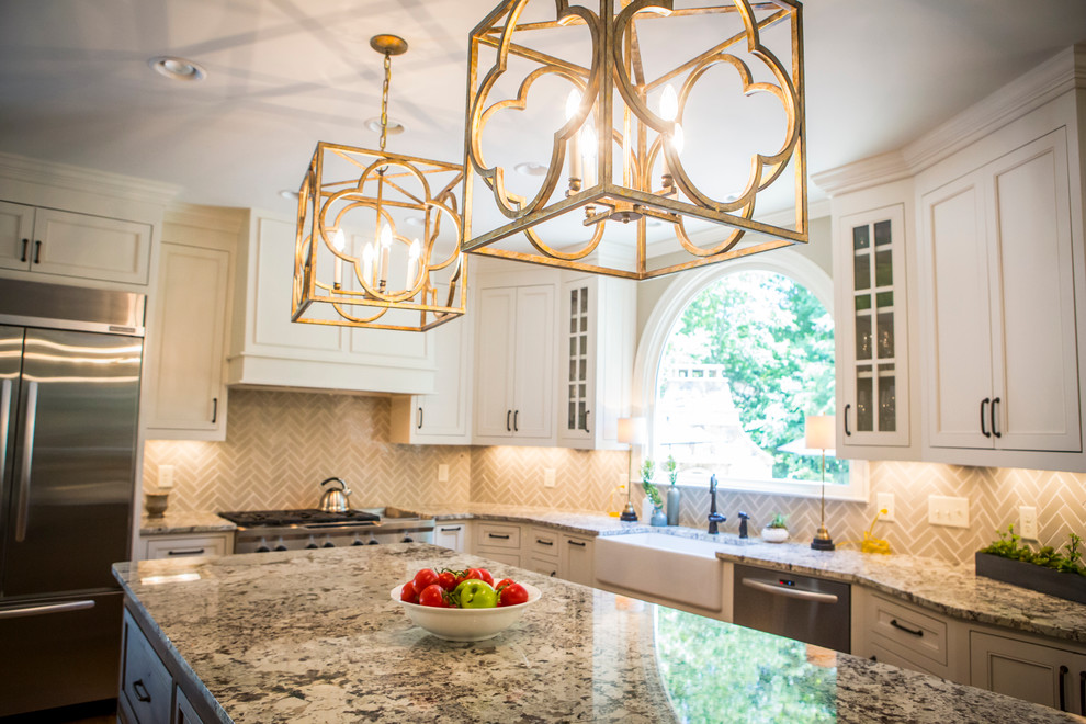 Example of a large transitional l-shaped medium tone wood floor eat-in kitchen design in Atlanta with a farmhouse sink, recessed-panel cabinets, white cabinets, granite countertops, gray backsplash, glass tile backsplash, stainless steel appliances and an island