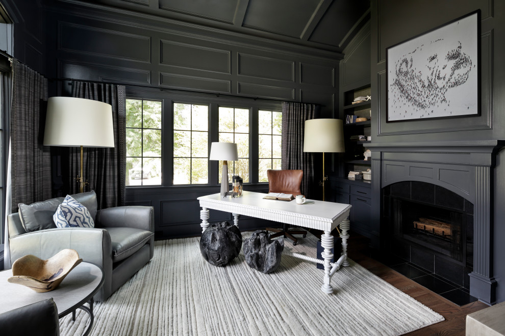 Photo of an expansive transitional home office in Atlanta with dark hardwood floors, a standard fireplace, a wood fireplace surround, brown floor, coffered and panelled walls.