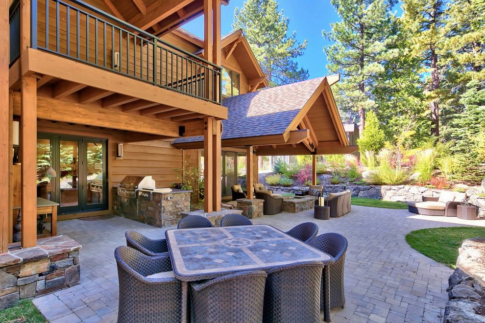 Inspiration for a large transitional backyard concrete paver patio kitchen remodel with a roof extension