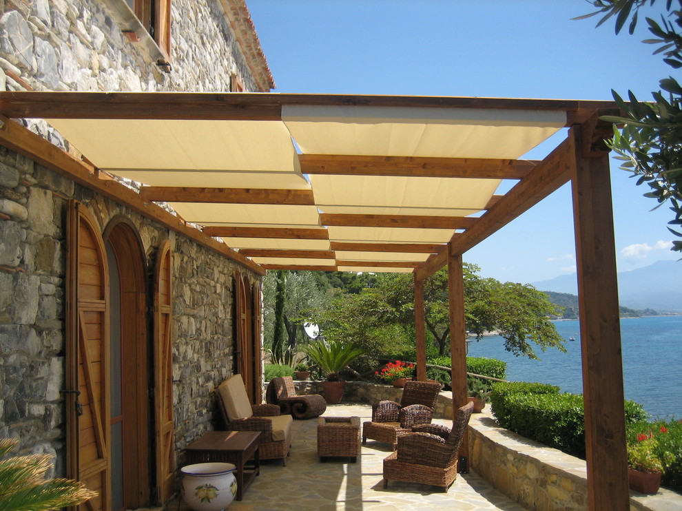 This is an example of a mediterranean deck in Naples with a pergola.