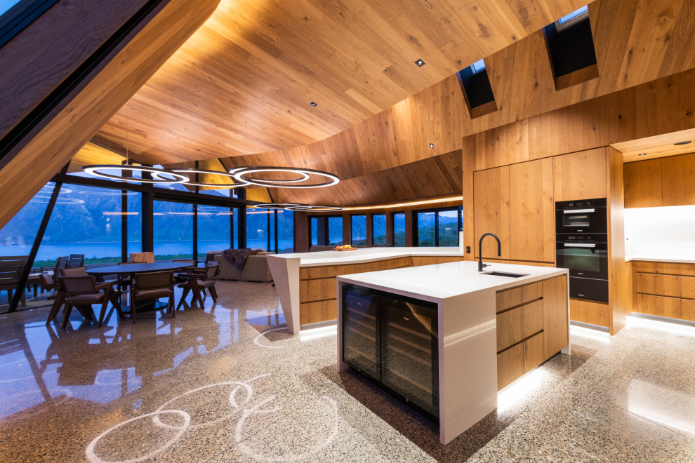 Inspiration for an expansive modern u-shaped open plan kitchen in Other with a single-bowl sink, marble splashback, black appliances, concrete flooring, multiple islands, grey floors and a wood ceiling.