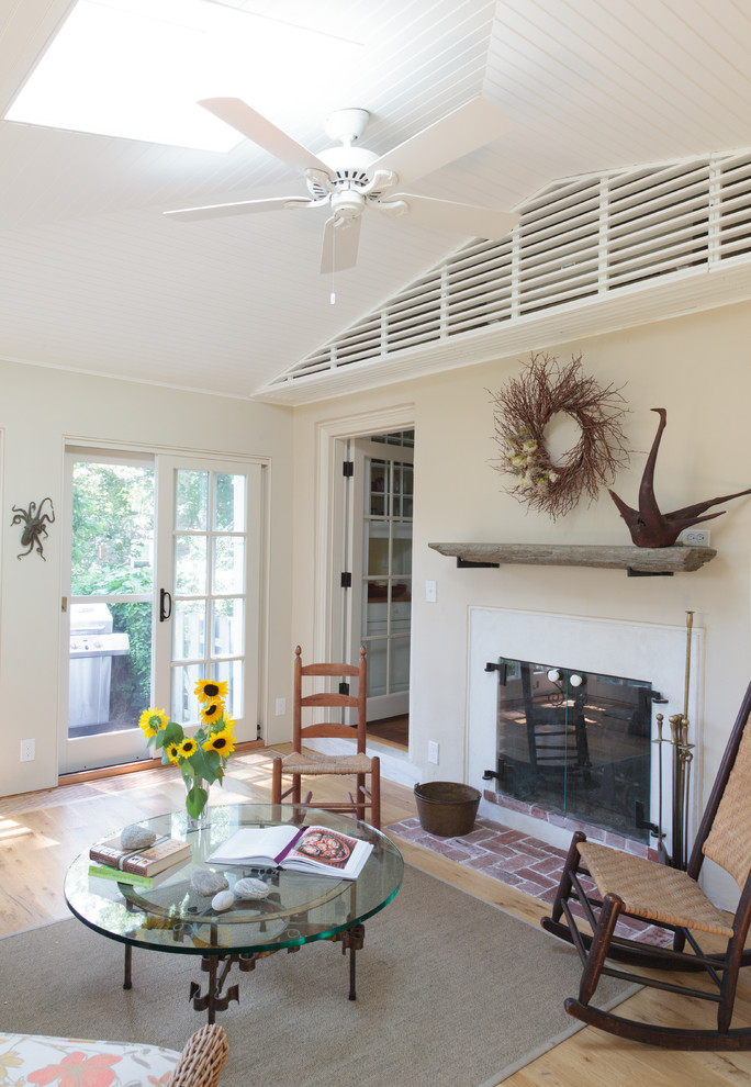 This is an example of a mid-sized traditional sunroom in Philadelphia with light hardwood floors, a two-sided fireplace, a plaster fireplace surround and a skylight.