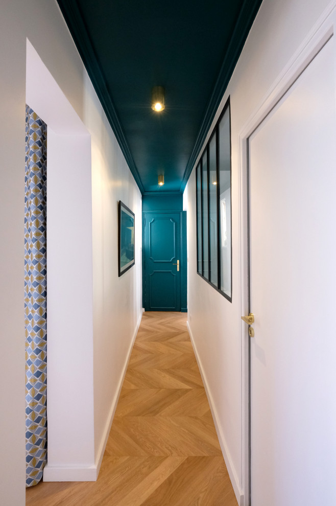 Idéer för en mellanstor modern hall, med blå väggar, ljust trägolv och beiget golv