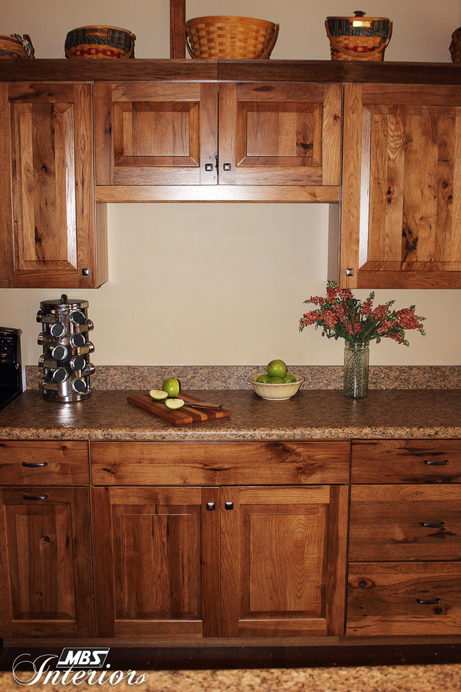 Inspiration for a rustic l-shaped kitchen remodel with recessed-panel cabinets, medium tone wood cabinets, laminate countertops and black appliances