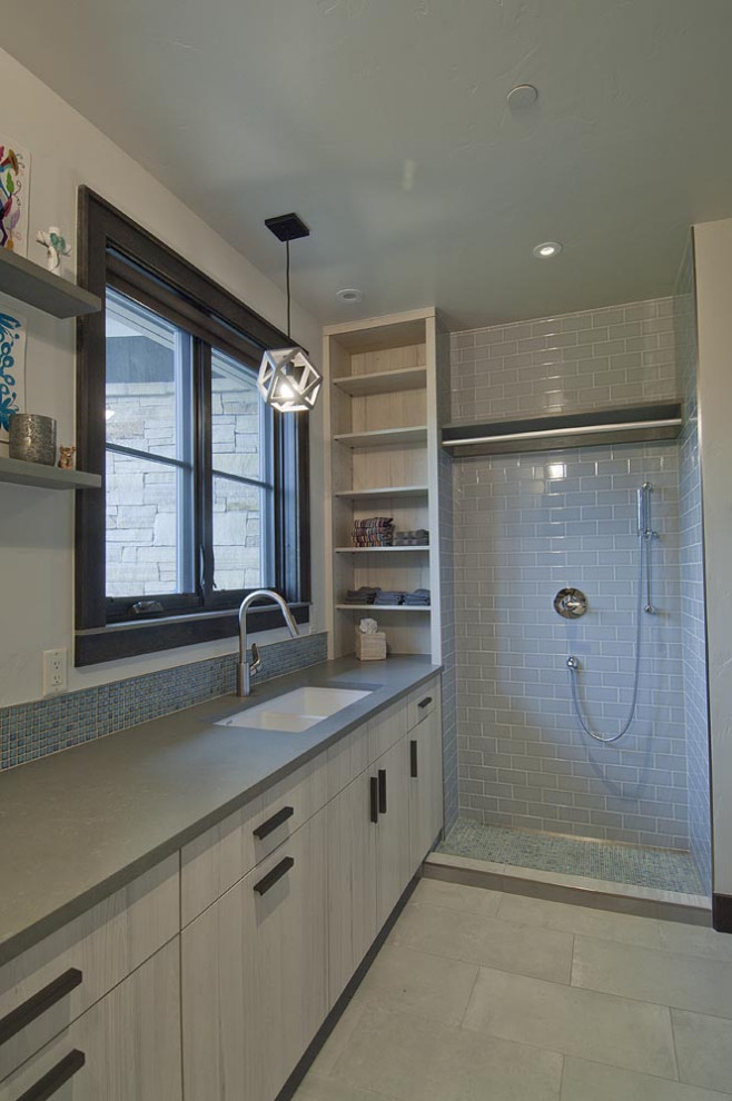 Inspiration for a mid-sized contemporary porcelain tile and gray floor laundry room remodel in Other with an undermount sink, flat-panel cabinets, white cabinets, a stacked washer/dryer and gray countertops