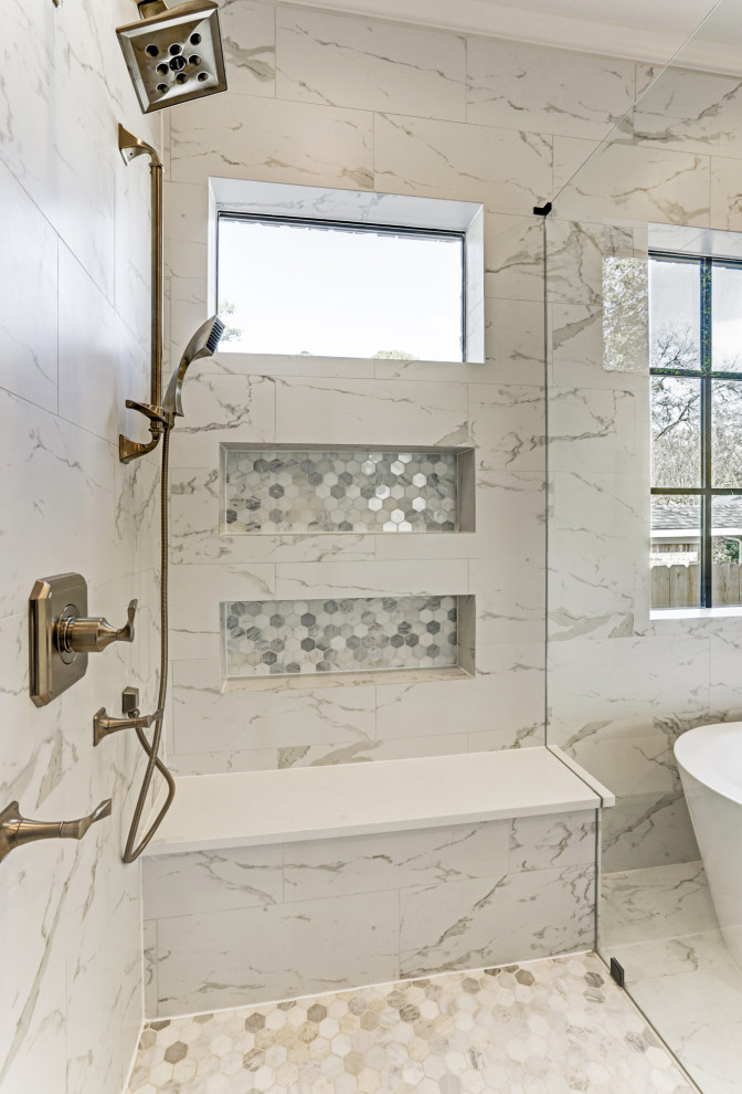 На фото: большая главная ванная комната в стиле неоклассика (современная классика) с фасадами с утопленной филенкой, серыми фасадами, отдельно стоящей ванной, угловым душем, раздельным унитазом, белой плиткой, мраморной плиткой, серыми стенами, мраморным полом, врезной раковиной, мраморной столешницей, белым полом, душем с распашными дверями, белой столешницей, сиденьем для душа, тумбой под две раковины и встроенной тумбой с