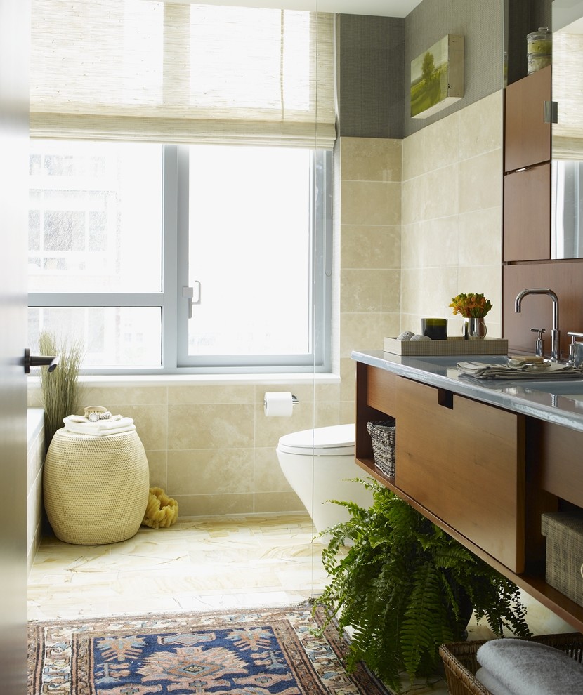 This is an example of an eclectic bathroom in New York with medium wood cabinets and beige tile.