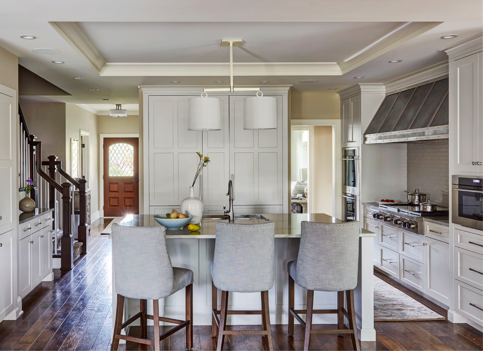 Mid-sized transitional u-shaped dark wood floor and brown floor open concept kitchen photo in Chicago with an undermount sink, shaker cabinets, white cabinets, marble countertops, gray backsplash, ceramic backsplash, stainless steel appliances, an island and beige countertops