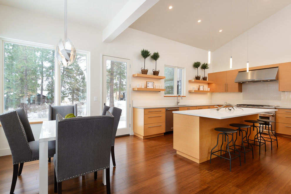 This is an example of a contemporary l-shaped eat-in kitchen in Other with a single-bowl sink, flat-panel cabinets, medium wood cabinets, quartz benchtops, white splashback, ceramic splashback, stainless steel appliances, bamboo floors and with island.
